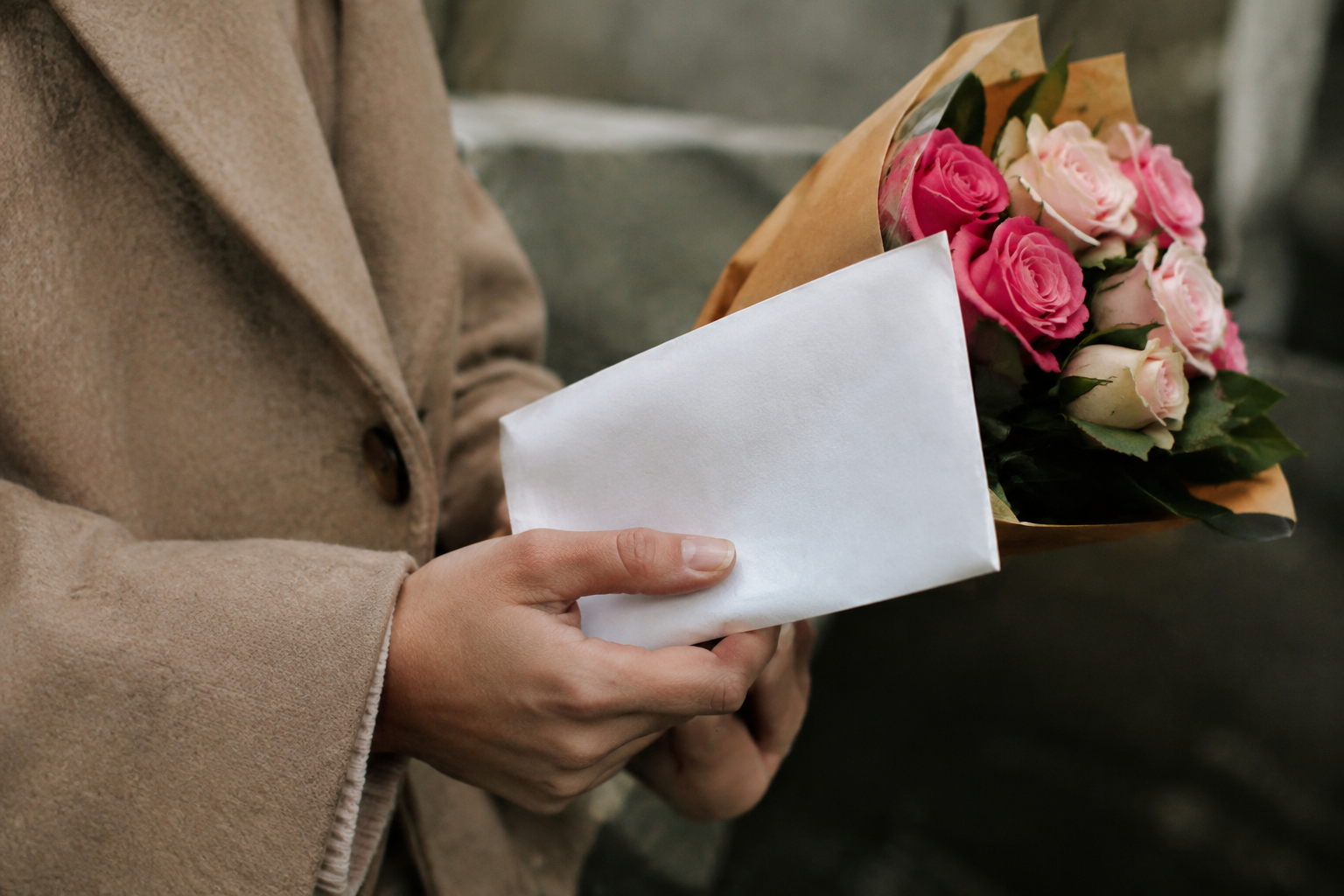 Mains jointes tenant lettre blanche manuscrite pres roses