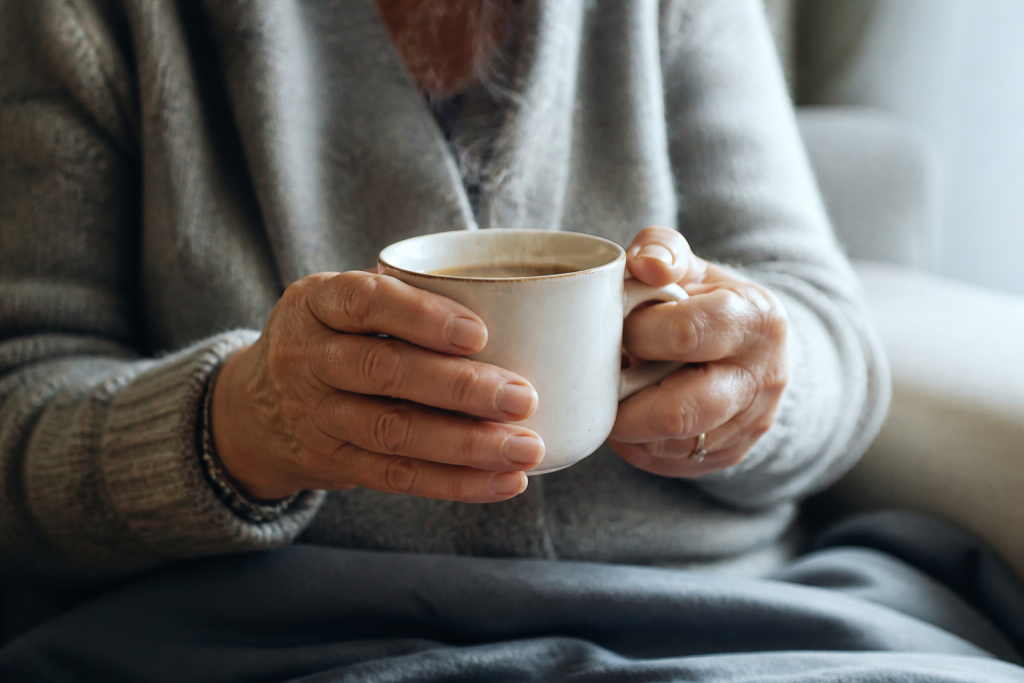 Mains de maman tenant une tasse fumante